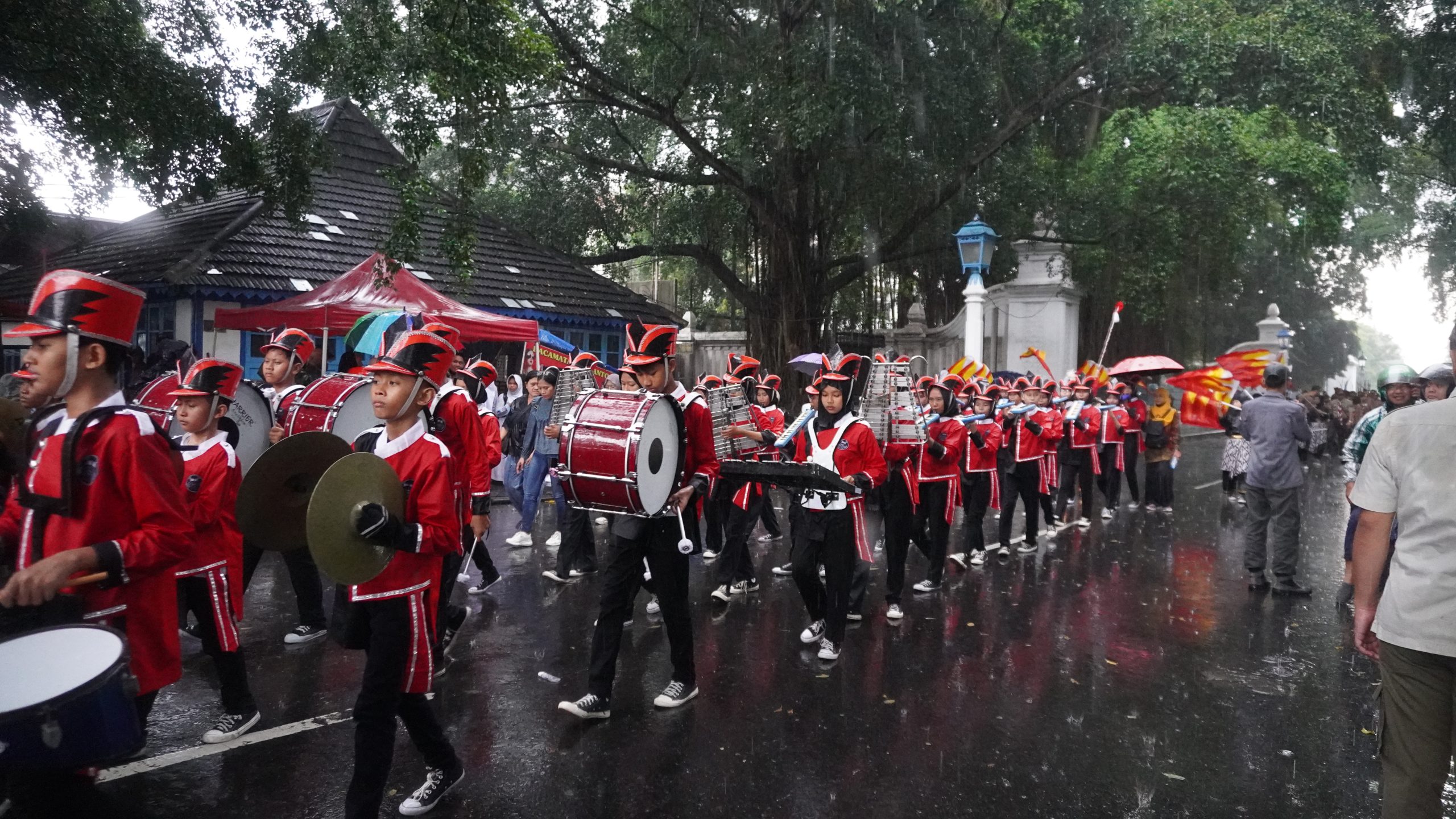 Drumband SekarJagad SMP Negeri 9 Kota Surakarta memimpin iring-iringan Mangayubagya Kirab Purna Tugas Wali Kota Surakarta, Teguh Prakosa di tengah hujan, Kamis (20/2/2025)